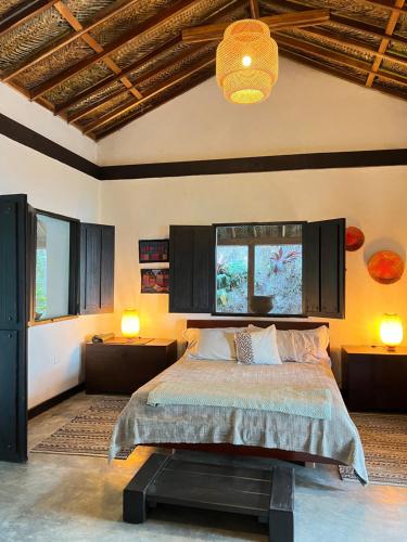 米卡Reserva Natural Tierra Adentro的一间卧室设有一张床、两盏灯和一个天花板。