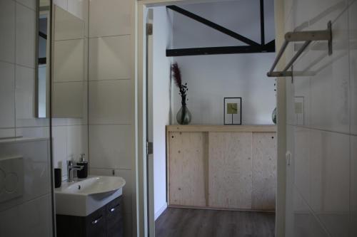 哈克斯卑尔根B&B Hoeve de Veldmaat的白色的浴室设有水槽和镜子
