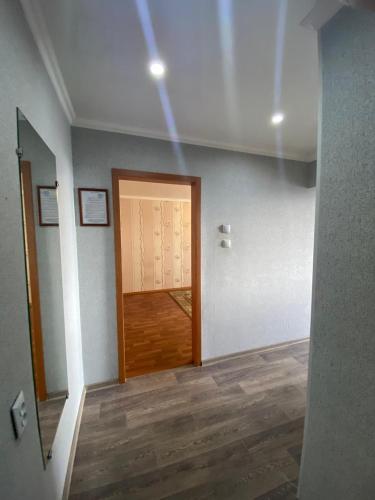 彼得罗巴甫洛夫斯克DEYA的走廊上设有门,位于一间铺有木地板的客房