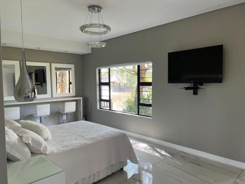 伯诺尼Swan Lake Suites的一间卧室配有一张床和一台平面电视
