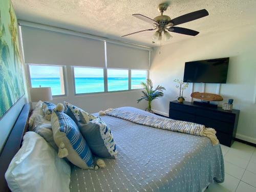 圣胡安Marbella del Caribe Isla Verde Beachfront的一间卧室配有一张床和吊扇