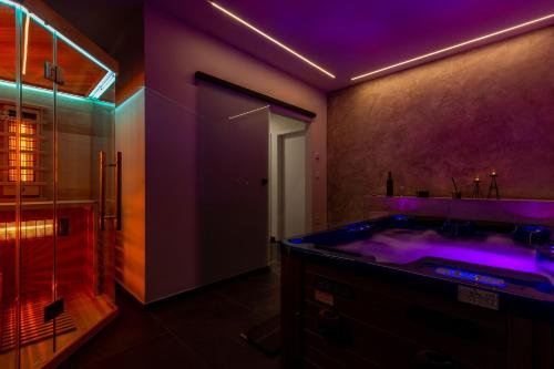 扎达尔Luxury Hedone Apartment near the Bridge with Private SPA Zone的浴室配有带紫色照明的大浴缸