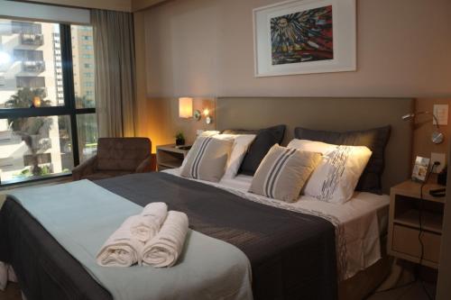 巴西利亚Flat Premium Particular Cullinan Hotel的酒店客房,配有带毛巾的床