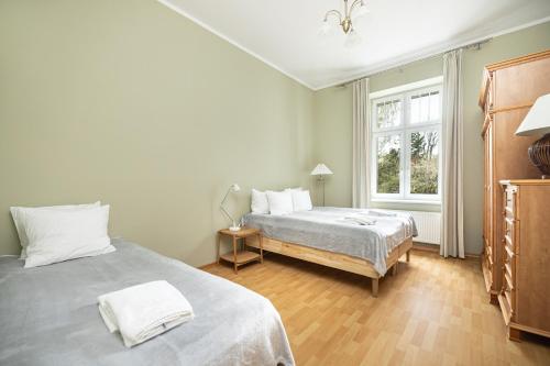 索波特Apartamenty Vincent Sopot的一间卧室设有两张床和窗户。