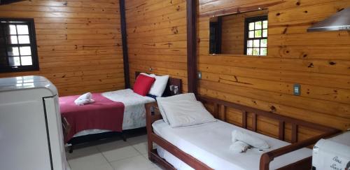 帕拉蒂Chalés internacional l的配有木墙和窗户的客房内的两张床