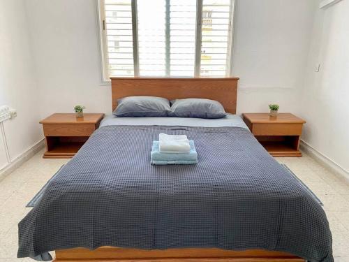 Qiryat H̱ayyimУютная квартира с двумя спальными的一间卧室配有一张大床和两张桌子