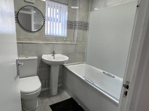 伦敦NEW! 4 Bedroom London House with Garden and Lawn的浴室配有盥洗盆、卫生间和浴缸。