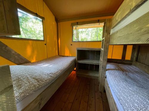 SeptfondsLodges du Bois Dodo - ancien Camping de Bois Redon的带两张双层床的客房,设有两扇窗户