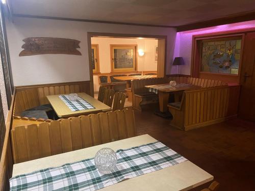比尔斯多夫Hotel-Restaurant Theis-Muehle的餐厅配有桌椅和紫色照明
