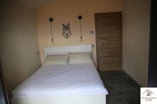 BusanaAntica Locanda Bonfiglio的卧室配有白色的床和门