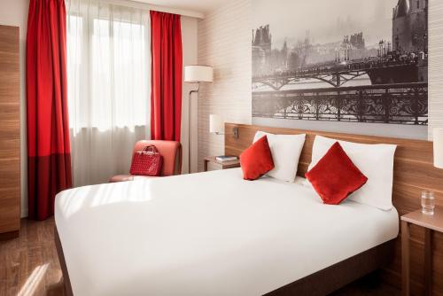 库尔布瓦拉德芳斯库尔布瓦阿德吉奥公寓式酒店的酒店客房配有一张带红色枕头的大床