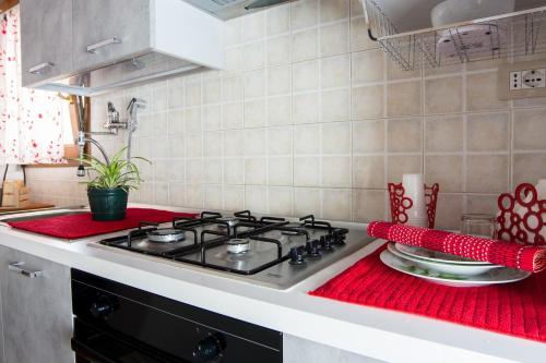 夸尔图-圣埃莱娜Colombohouse87的厨房配有炉灶,柜台上设有红色的布料