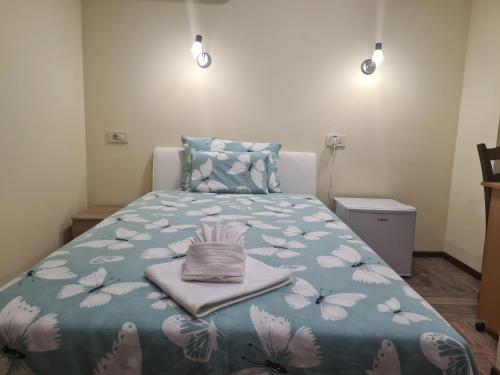 克宁SLATKI SNOVI II的一间卧室配有一张带蓝色棉被的床