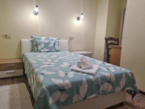 克宁SLATKI SNOVI II的一间卧室配有一张带蓝色花卉床罩的床。