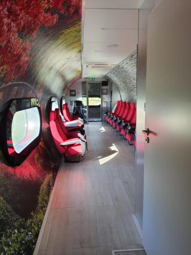 Wiślicanormobaria Górki的一间火车室,配有红色椅子和隧道