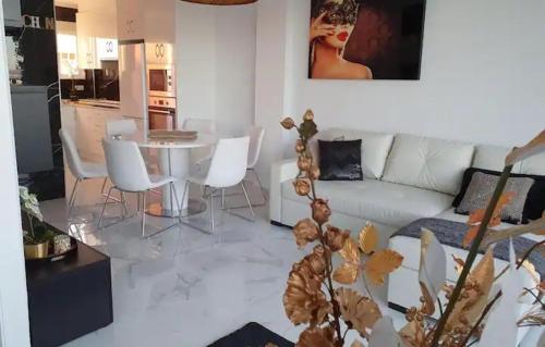 蓬塔普里马Modern penthouse with sea view的客厅配有白色的沙发、桌子和椅子