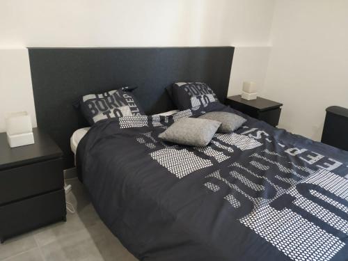 阿格德角Résidence Odalys Saint Loup Appartement Climatisé entierement rénové的一张带黑色棉被和枕头的床