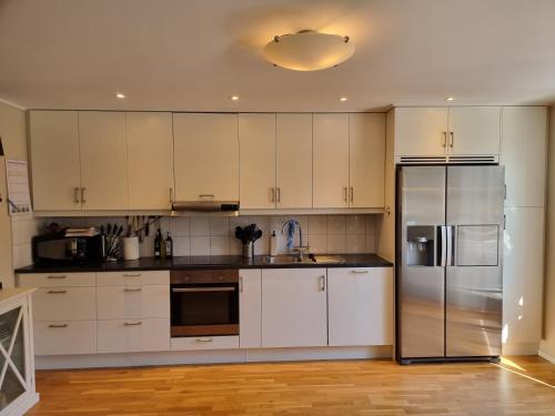 斯特伦斯塔德Trevlig lägenhet nära Strömstad centrum的厨房配有白色橱柜和不锈钢冰箱