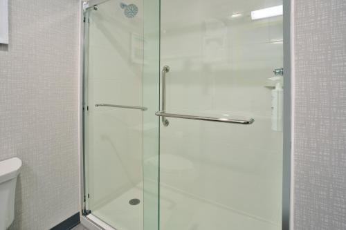 ParisHampton Inn Paris, Tn的浴室里设有玻璃门淋浴