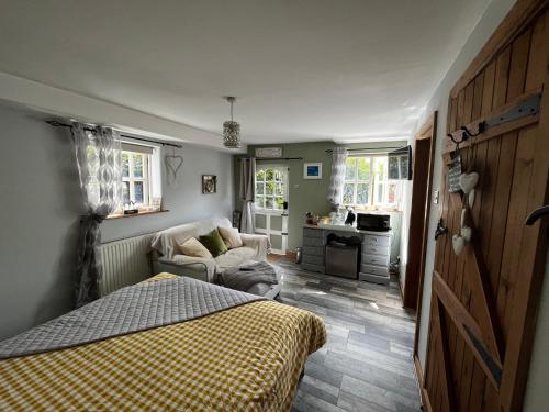 什鲁斯伯里Pear Tree Cottage的一间卧室配有一张床和一张沙发,还设有一间厨房