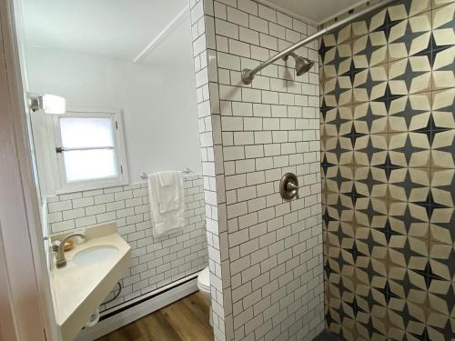 缪尼辛Scotty's Motel的白色的浴室设有水槽和淋浴。