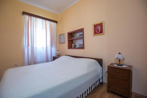 普契什查Visilo Stone House的卧室配有白色的床和窗户。