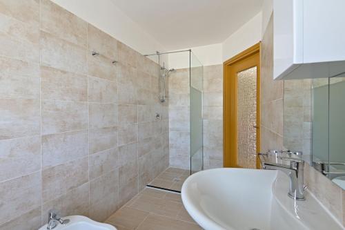 马内尔巴La Grolla Apartments的浴室配有盥洗盆和浴缸。
