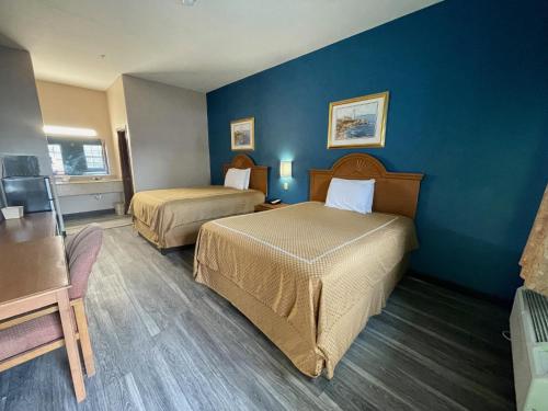 科珀斯克里斯蒂Airport inn & suites的酒店客房设有两张床和蓝色的墙壁。