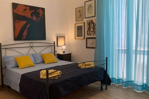 马尔扎梅米Casa Franca a Marzamemi的一间卧室配有一张带蓝色窗帘的大床