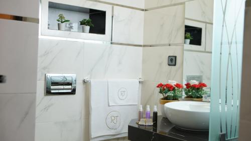 TaounateHotel Riad Taounate的浴室设有水槽,在柜台上摆放着红色鲜花