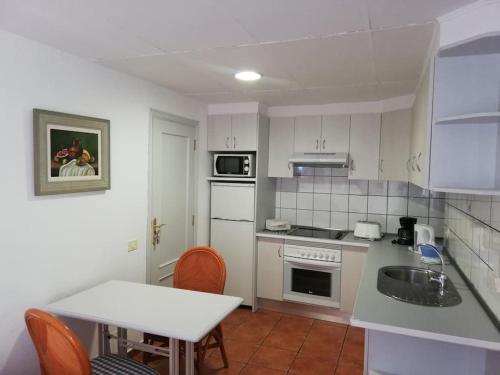 塔扎克蒂apartamento CASA TELA的厨房配有白色家电和桌椅