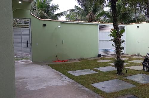帕拉蒂pousada Cantinho da mata的旁边是一座带棕榈树车库的房子