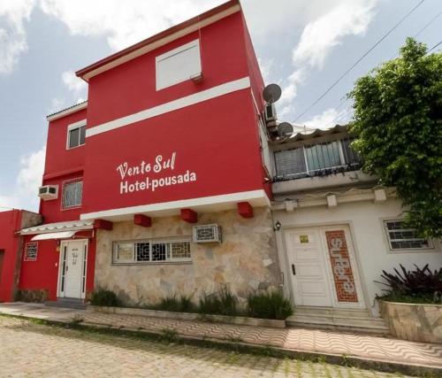 里奥格兰德Hotel Pousada Vento Sul的一座红色的建筑,上面写着你仍然要求的文字