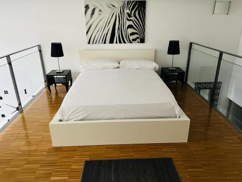 阿尔卡拉德荷那利斯Loft Confort的卧室配有白色的床,墙上挂着斑马图