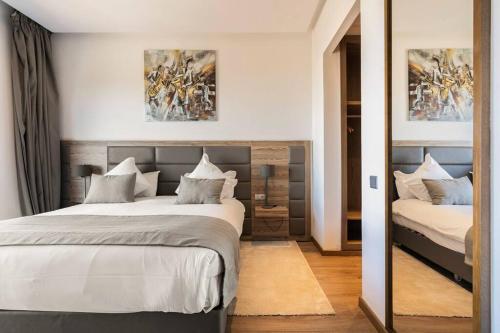 卡萨布兰卡Sublime Appart sur la Corniche , Luxueux et Vue sur Mer的一间卧室配有两张床和镜子