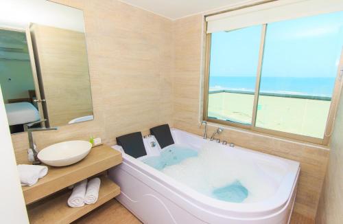 卡塔赫纳海滨夏日酒店的一间带大浴缸及大窗户的浴室