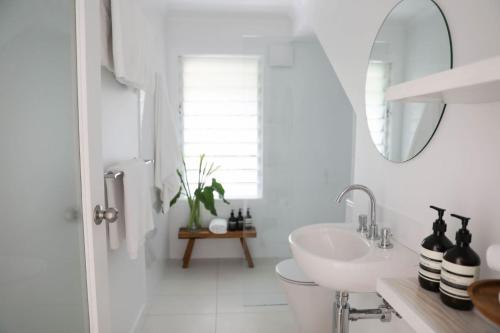 拜伦湾Sirens的白色的浴室设有水槽和镜子