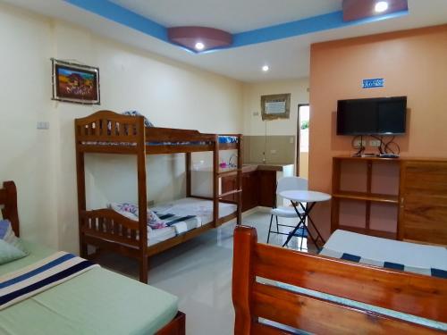 公主港D&D Travellers INN的一间卧室配有两张双层床和一台平面电视