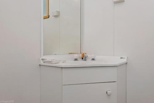 金斯顿霍巴特布什假日公园的白色的浴室设有水槽和镜子