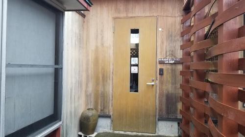 安昙野市Shino's Farm Inn的走廊设有木门和窗户