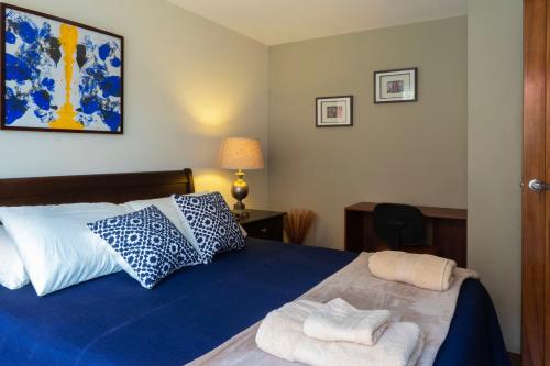 危地马拉Apartamentos 649的一间卧室配有蓝色的床和毛巾