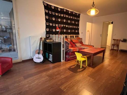 马西Spacious & cosy flat的带沙发、桌子和吉他的客厅