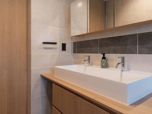 读谷村Bosco Yomitan Resort Condminium的客房内的白色盥洗盆浴室