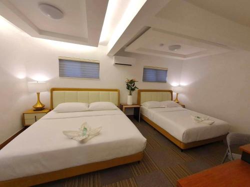 克拉克Aurora Villas and Cabin Resort的带2张桌子和窗户的客房内的2张床