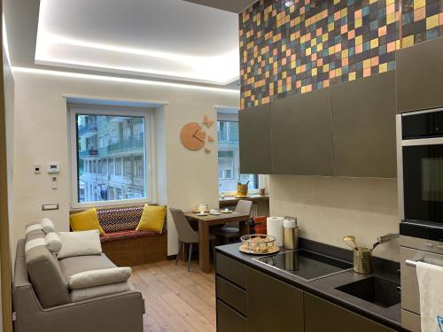 萨莱诺Civico Cinque Home Luxury Apartment的厨房配有沙发、椅子和桌子