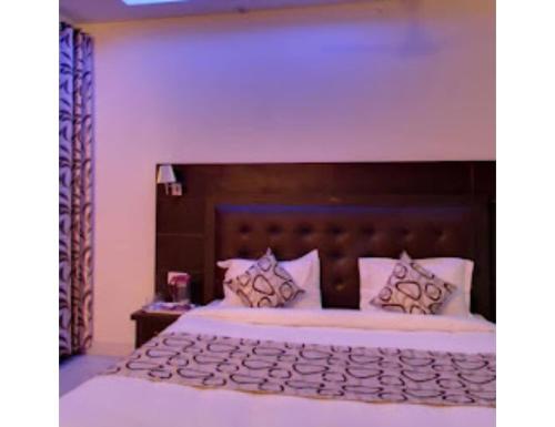 康格拉Hotel lords Highway Inn, Gagal Khas的一间卧室配有一张大床和木制床头板
