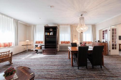 韦塞尔豪斯杜特恩酒店的一间带桌子的客厅和一间餐厅