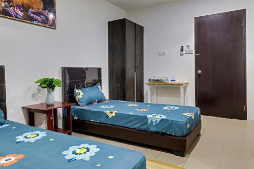 诗巫SPOT ON 90439 Lh Home的一间卧室配有两张带蓝色花卉床单的床