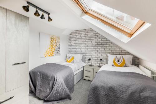 BansteadSurrey Stays - 4 bedroom house, sleeps 9, 2 bathrooms, CR5, near Gatwick Airport的带阁楼的客房内的两张床