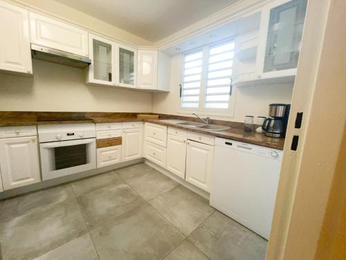 FilaosL'Hermitage - Appartement T3 en bord de plage的厨房配有白色橱柜和白色家电